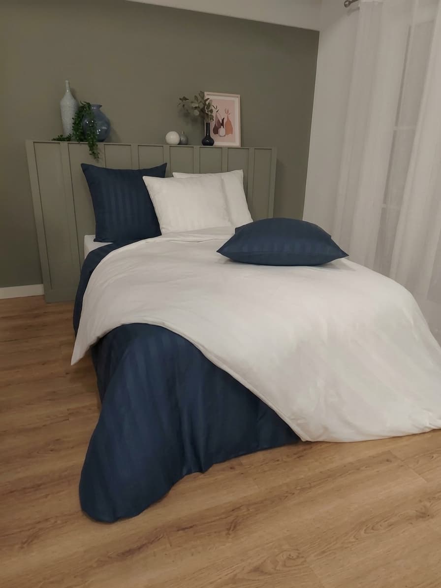 Chambre sobre aux tons vert de gris, linge blanc et bleu nuit