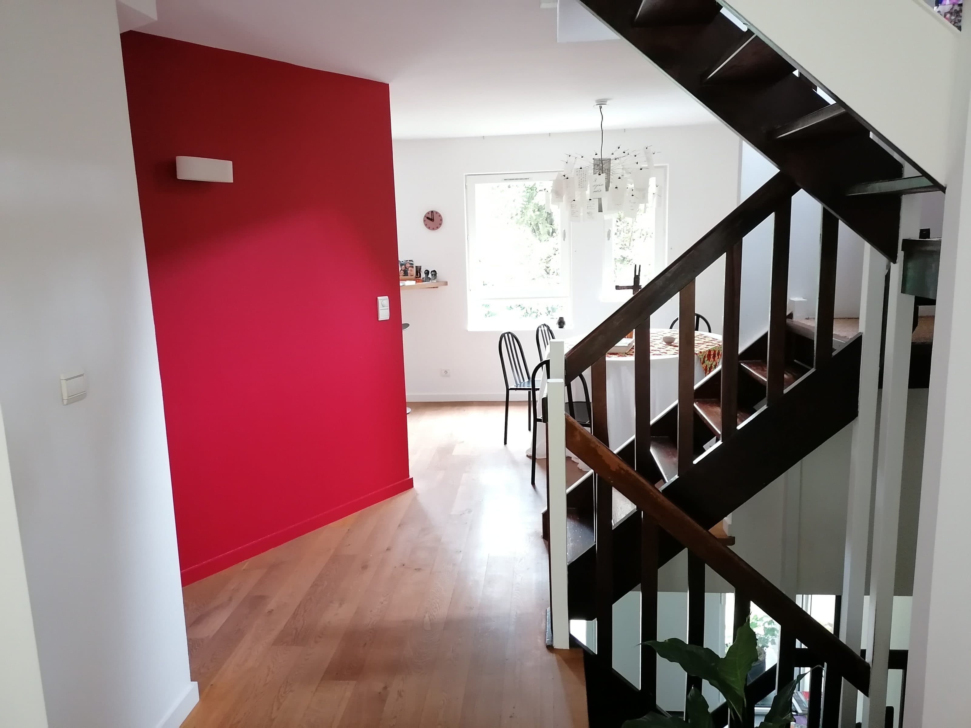 Mur rouge framboise dans un séjour avec escalier