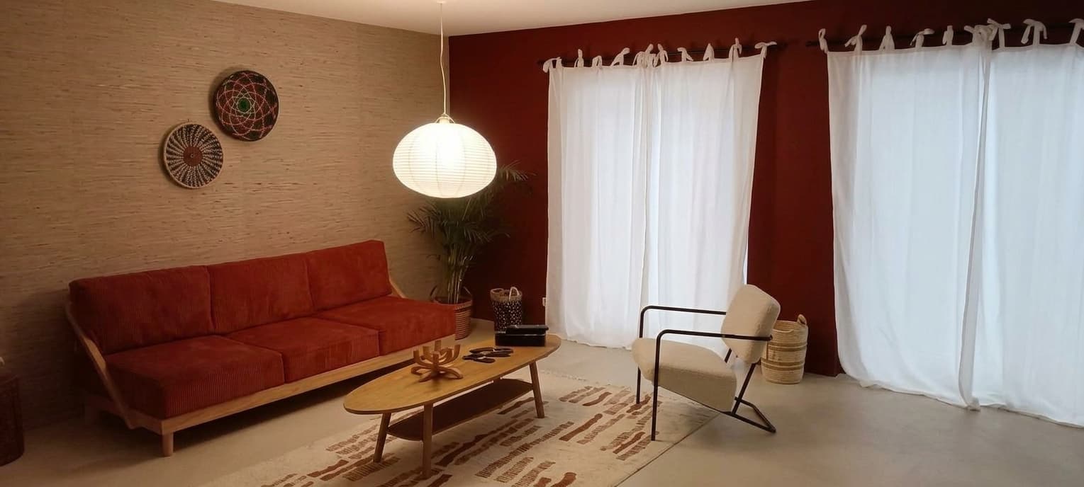 Salon avec papier peint texturé et mur rouge profond